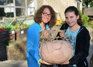 Die Schülerpraktikantinnen Liv und Theresa mit dem 14,8 Kilo-Kürbis vom UBZ. Foto: Mathias Kehren