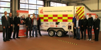 (v.l.) Benedikt Lamerz, Rainer Stauff und Marco Zerweiss zusammen mit eingeladenen Spendern vor dem neuen Anhänger der Jugendfeuerwehr. (Foto: Kreisstadt Mettmann)