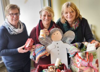 Christa Beyer, Tanja Högström und Renate Zenjani von der Tafel für Niederberg zeigen, was in eine Weihnachtstüte gepackt werden kann. Foto: Mathias Kehren
