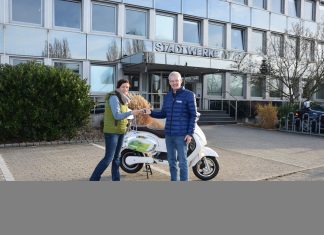 Frank Schlosser von den Stadtwerken übergibt der Gewinnerin Britta Averdick die Schlüssel für den Kumpan Elektroroller 1954L. Foto: Stadtwerke Ratingen
