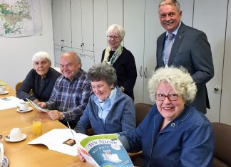 Das Projektteam der Seniorenzeitung "Wir älteren" hält die 100. Ausgabe in Händen: Dagmar Haarhaus, Armin Merta, Rosemarie Koch, Ursula Schwarze, (vordere Reihe v.l.), Dr. Jutta Scheidsteger, Michael Beck (VHS-Verbandsvorsteher). Foto: VHS