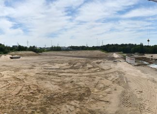 Die Baumaschinen haben die Fläche für den Stadionrasen schon geebnet, rechts im Bild wird mit dem Kran an der Tribühne gebaut. Im Hintergrund ist das Sportzentrum zu erkennen. Foto: Mathias Kehren