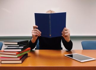 Ein Mann hinter Büchern. Foto: Symbolbild (pixabay)