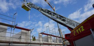 Die Wehr bereitet die Rettung des verletzten Bauarbeiters mittels Drehleiter und Flaschenzug vor. Foto: Feuerwehr