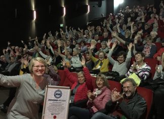 Im Anschluss an Film, Kaffee und Kuchen: Henriette Muhr und die Kinobesucher freuen sich über die Urkunde. Foto: Weltspiegel