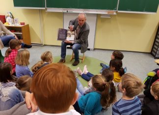 Martin Sträßer erzählt die Geschichte über die Reise einer Maus zum Mond - und die Grundschüler lauschen gebannt. Foto: PR Sträßer MdL