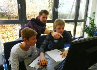 Student Marc Ledwig erklärt Philipp und Philipp die nächsten Schritte im ERP-System. Foto: Kreis ME