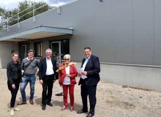 Der Rohbau für den neuen Tafel-Laden steht, darüber freuen sich (von rechts) Volkmar Schnutenhaus (WoGeRa), Ingrid Bauer (Tafel Ratingen), Bürgermeister Klaus Pesch sowie Marcus Lücker und Kathrin Beckmann (LückerBeckmann Architekten). Foto: Stadt Ratingen