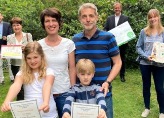 Die Projektpartner - hinten v.l.n.r. Jürgen Rodenbröker von den Stadtwerken Ratingen, Susanne Berger von der Verbraucherzentrale NRW, Matthias Stephany von der Sparkasse HRV und Elena Plank, Klimaschutzmanagerin der Stadt Ratingen - überreichen den Hauptpreis der Energiesparmeisterschaft an Familie Plociennik (vorne). Foto: Verbraucherzentrale NRW