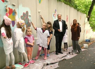 Bürgermeister Thomas Dinkelmann und Tamara Tabaković-Halilović vom IKZ mit zahlreichen Kindern bei der Malaktion am Brücker Berg. Foto: Kreisstadt Mettmann