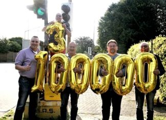 Vor der Ampel an der Lindenschule hat sich die Wülfrather Gruppe mit Jubiläumsballons aufgestellt. Foto: WG