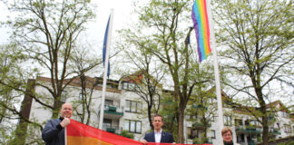 Bürgermeister Christoph Schultz (m.) und seine Stellvertretung Regina Wedding (r.) sowie Marc Göckeritz (l.) setzen gemeinsam ein Zeichen gegen Homophobie und Transphobie und hissen am Europaplatz in Hochdahl eine Regenbogenfahne. Foto: Stadt Erkrath