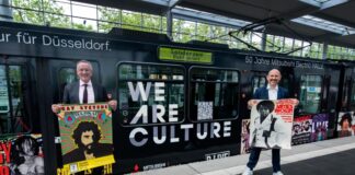 Klaus Klar, Vorstandsvorsitzender und Arbeitsdirektor der Rheinbahn, und Michael Brill, Geschäftsführer von D.LIVE., präsentieren die Bahn mit Highlights aus 50 Jahren Mitsubishi Electric Halle. Foto: Rheinbahn