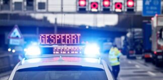 Auf einem Polizeifahrzeug leuchtet die Aufschrift "Gesperrt". Foto: David Young/dpa/Symbolbild