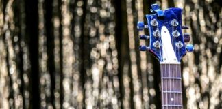 Eine Gitarre vor einem Vorhang. Foto: pixabay/symbolbild