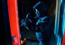 Ein Einbrecher hebelt ein Fenster auf. Foto: Polizei/Symbolbild