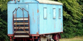 Ein alter Bauwagen steht auf einer Wiese. Foto: pixabay/Symbolbild