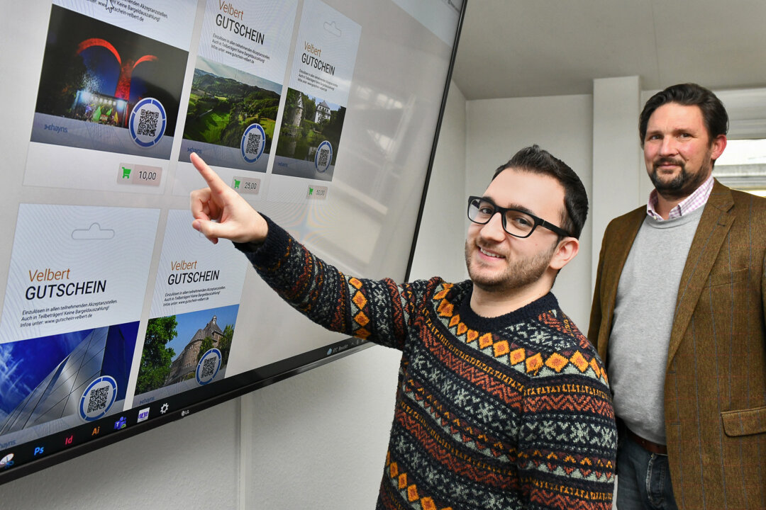 Den Velbert Gutschein gibt es mit verschiedenen Motiven. Wer will kann auch selbst designen. Claudiu Heidrich und Olaf Knauer sind Ansprechpartner für Händler und Gastronomen, die Akzeptanzstelle werden möchten. Foto: Mathias Kehren