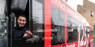 Der Miniaturbus passt genau auf eine Handfläche. Das tonnenschwere Original fährt nur noch bis Ende März 2022 im Jubiläumskleid durch das Netz der Rheinbahn. Foto: Rheinbahn