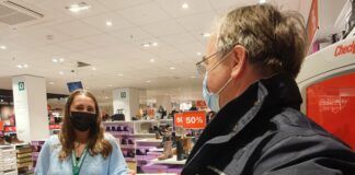 Ein Mitarbeiter der Ordnungsbehörde überreicht die 2G-Bändchen in einem Schuhgeschäft. Foto: Kreisstadt Mettmann
