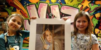 Mara (links) und Leonie aus Eggerscheidt erfreuen sich an dem Bild "Hoffnung" von Helda Kutish. Foto: Stadt Ratingen