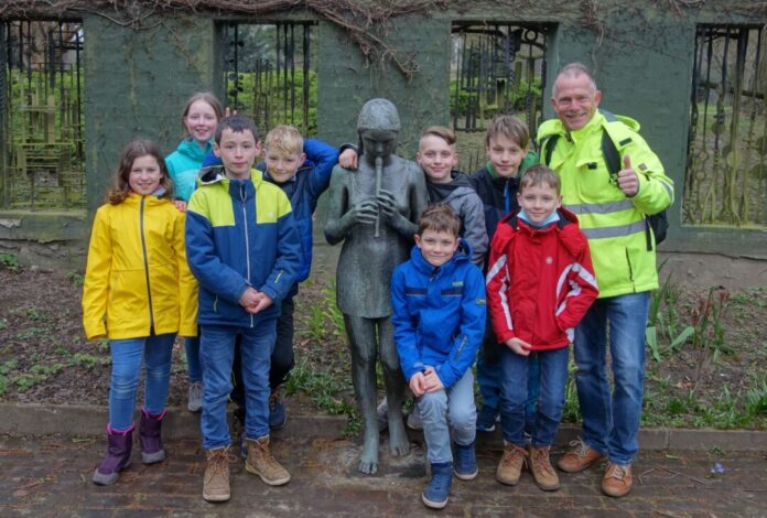 An der Bronze-Skulptur „Kind mit Blockflöte" des Bildhauers Hermann Geibel versammelten sich die Kulturrucksäckler mit Michael Baaske zu einem Gruppenbild. Foto: Stadt Ratingen