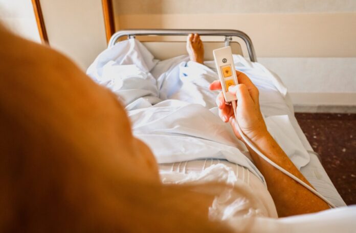 Eine Frau liegt in einem Pflegebett. Foto: VZ NRW/Adpic