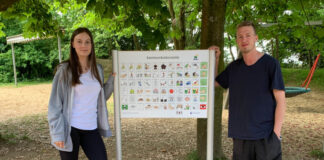 Lea Schlottmann und Luca Kläs vor der Kommunikationstafel auf dem Schulhof der Förderschule an der Virneburg in Langenfeld. Foto: Kreis ME