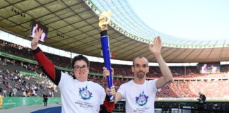 Robert Herberg, Gesicht der Special Olympics Nationalen Spiele Berlin 2022, und Athletin Juliana Rößler präsentieren gemeinsam die Fackel von Special Olympics. Foto: Special Olympics