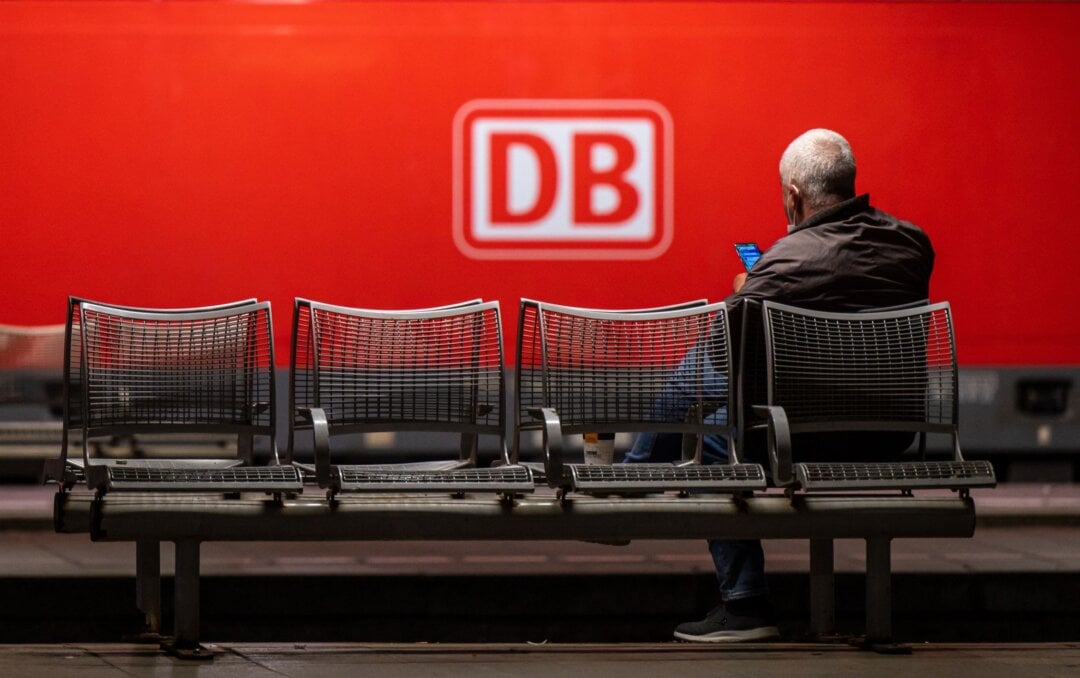 Ein Mann wartet auf einer Bank in einem Hauptbahnhof.