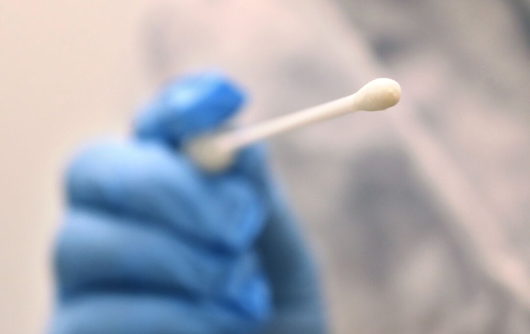 Corona-Test Ein Arzt hält einen Tupfer, mit dem ein Abstrich für einen Coronatest gemacht wird.