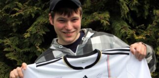 JUZ-Eggerscheidt-Besucher Andreas Harke zeigt den Hauptpreis: ein signiertes Nationaltrikot von 2010. Foto: Stadt Ratingen