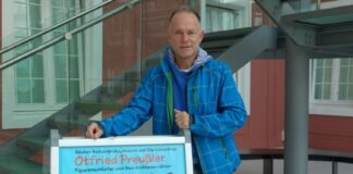 Jugendamtsmitarbeiter Michael Baaske, hier vor einem Ausstellungsplakat im Foyer der Ludwigsgalerie im Schloss Oberhausen, wird die Schülergruppe in den Ferien begleiten. Foto: Stadt Ratingen