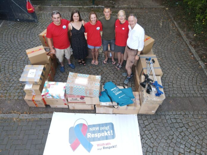 Heiko Dietrich (l.) mit Inna Klod-Schlieper (M.), Rotarier Jan Bruns (r.) und weiteren engagierten Helfenden. Foto: DLRG