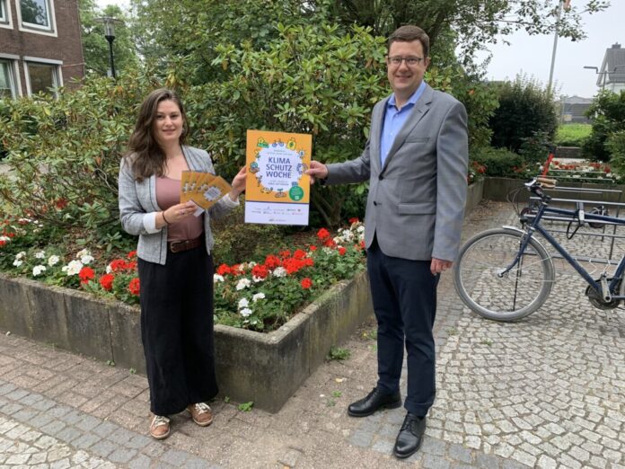 Helena Lohneis (Kreiskoordinatorin der Klimaschutzwoche) und Kreisdirektor Philipp Gilbert präsentieren das Plakat zur Klimaschutzwoche. Foto: Kreis Mettmann