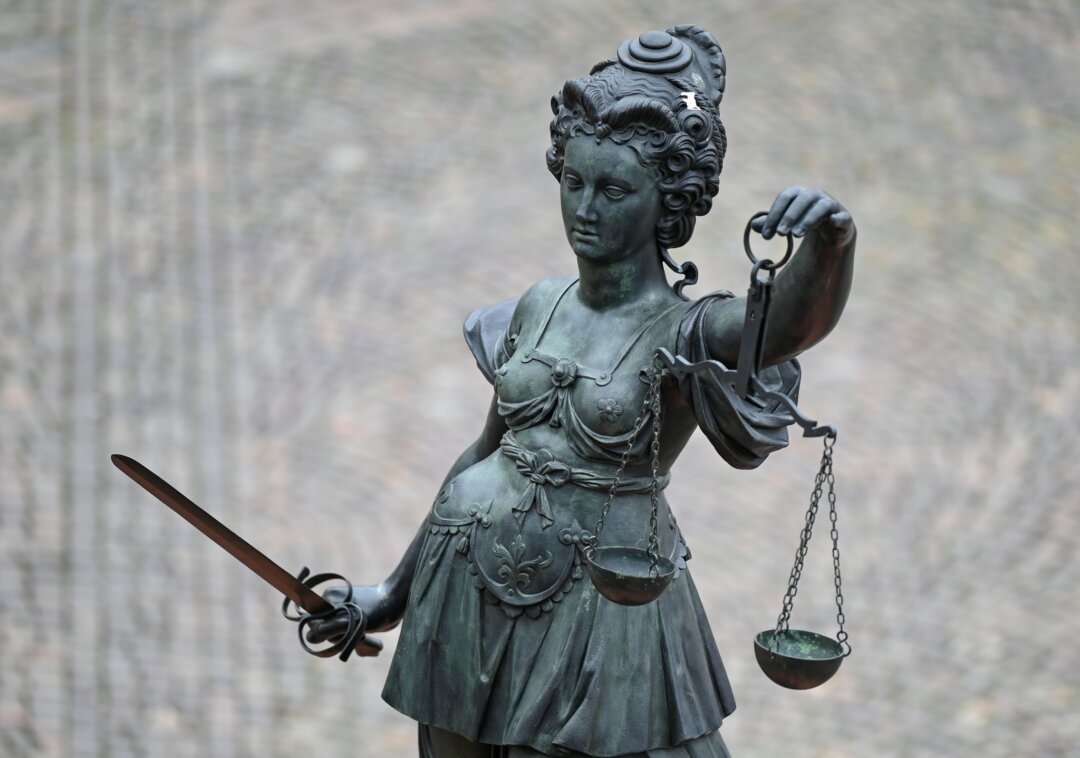 Justitia Eine Statue der Justitia hält eine Waage und ein Schwert in der Hand.