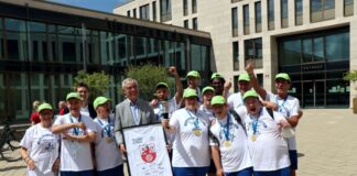 Bürgermeister Klaus Pesch und Sportdezernent Patrick Anders (3.v.l.) ehrten die erfolgreiche Fußballmannschaft der BSG Ratingen vor dem Rathaus. Als Dank für die städtische Unterstützung überreichte die BSG dem Bürgermeister ein gerahmtes Trikot mit den Namen der Teammitglieder. Foto: Stadt Ratingen