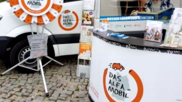 Am ALFA-Mobil-Stand informieren Mitarbeitende interessierte Bürger und Menschen mit Lese- und Schreibschwierigkeiten. Foto: ALFA-Mobil