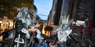 Die Stelzenläufer erinnern mit ihren Kostümen an einen venezianischen Maskenball - klar das sie ein beliebtes Fotomotiv sind. Foto: Mathias Kehren