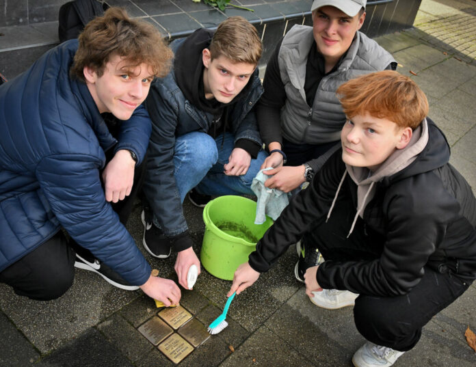 Adrian Heinz, Myron Thiele, Paul Nagel und Nikos Loos polierten die Oberfläche der Stolpersteine, die an das Schicksal der Familie Isaac erinnern. Foto: Mathias Kehren