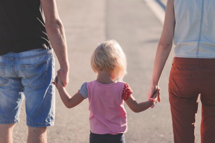 Eltern gehen mit einem Kind spazieren. Symbolfoto: Pixabay