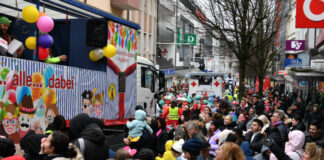 Karnevalszug mit vielen feiernden Menschen.