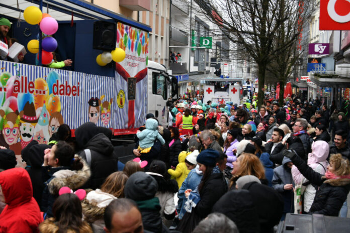 Karnevalszug mit vielen feiernden Menschen.