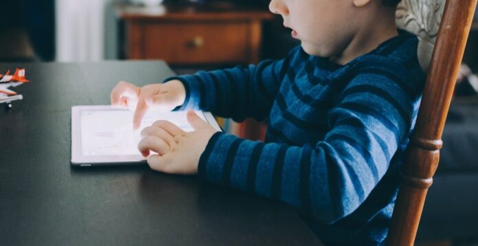 Ein Kind sitzt am Tisch vor einem Tablet. Foto: pixabay