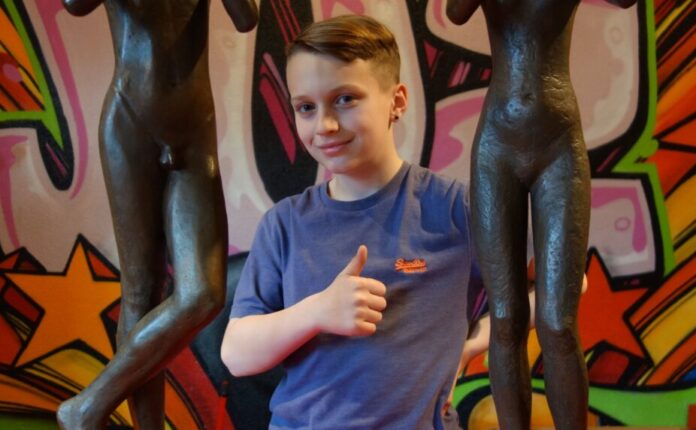 Der elfjährige Jayden aus Eggerscheidt freut sich auf den Workshop - hier zu sehen zwischen zwei Plastiken, die bei dem Workshop mit von der Partie sind. Foto: Stadt Ratingen