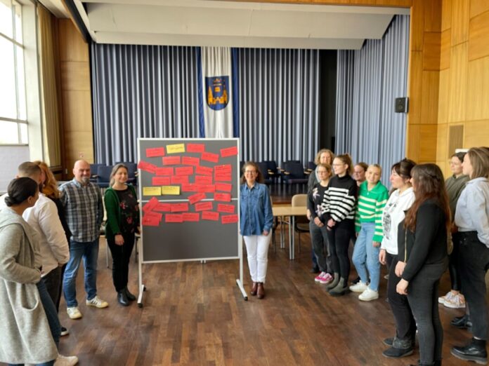 Kezban Demir (links an der Tafel) und Karen Holle (rechts an der Tafel), Mitarbeiterinnen des Mettmanner Jugendamtes, schulten zwei Tage lang junge Kolleginnen und einen Kollegen aus Jugendämtern der Nachbarstädte. Bürgermeisterin Sandra Pietschmann (rechts im Hintergrund) und Jugendamtsleiter Stephan Paas (links) begrüßten die Gäste. Foto: Kreisstadt Mettmann