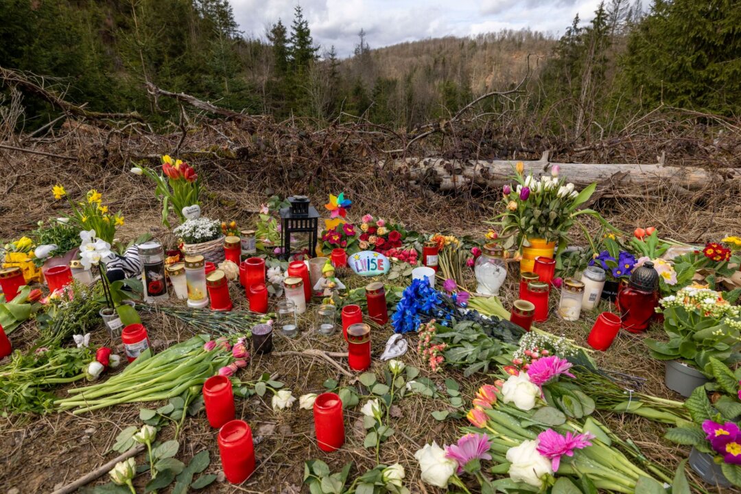 Kerzen, Blumen und Kuscheltiere liegen an der Stelle im Wald.