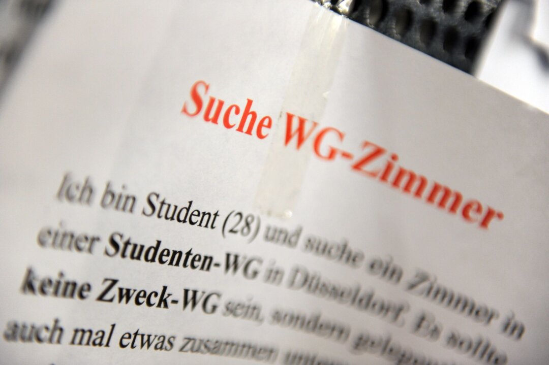 Ein Zettel eines WG-Zimmer-Suchenden hängt an einem Schwarzen Brett.