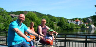 Familie Sieper aus Remscheid auf einer Draisine - der erste Vorsitzende des Wuppertrail-Vereins Dennis Jaroschek (Warnweste) begleitet die Tour. Foto: Wuppertrail