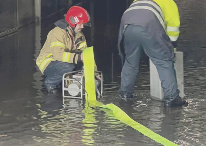 Einsatzkräfte pumpen Wasser aus einer Garage. Foto: FW Ratingen